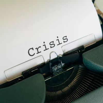 Close-up of a vintage typewriter with the word 'Crisis' typed on paper.