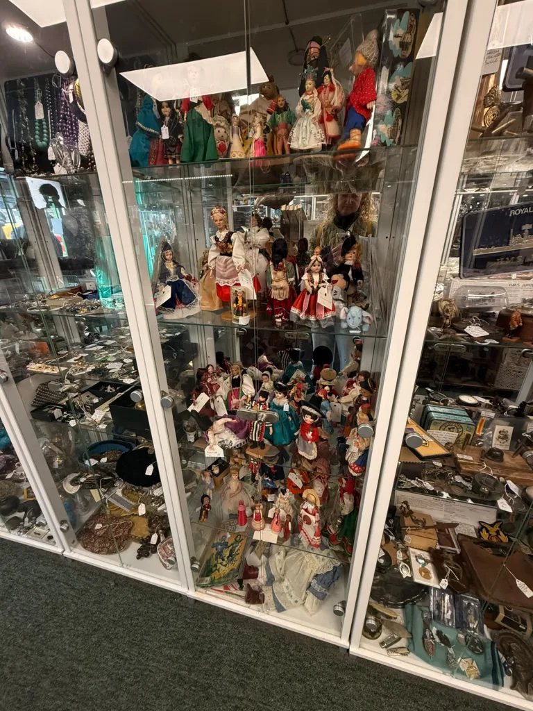 Glass cabinet of vintage costume dolls at Antiques on High, Bowness