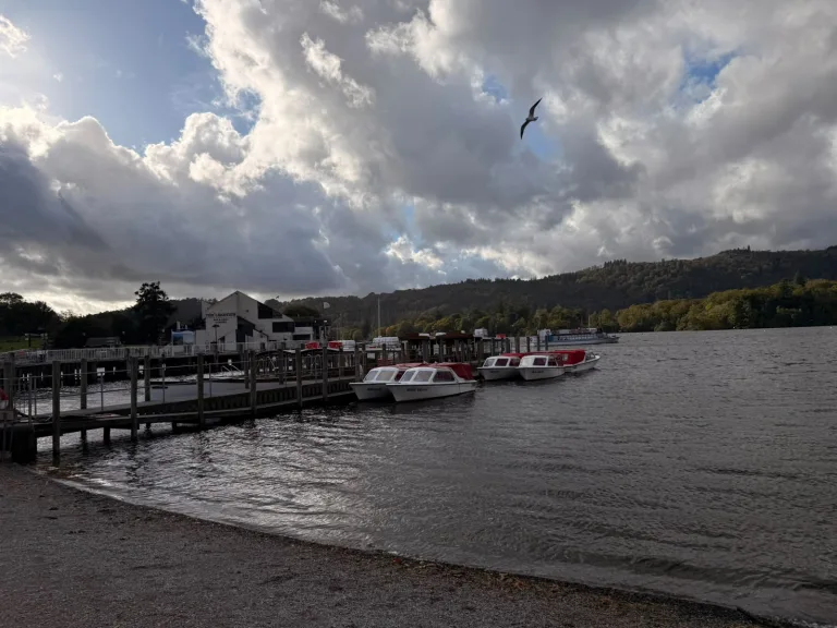 Bowness-on-Windermere history walk: boats at Bowness pier under autumn clouds