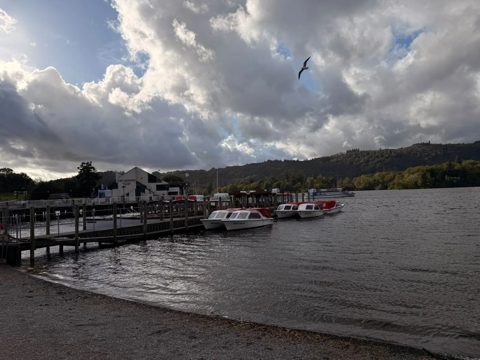 Bowness-on-Windermere history walk: boats at Bowness pier under autumn clouds