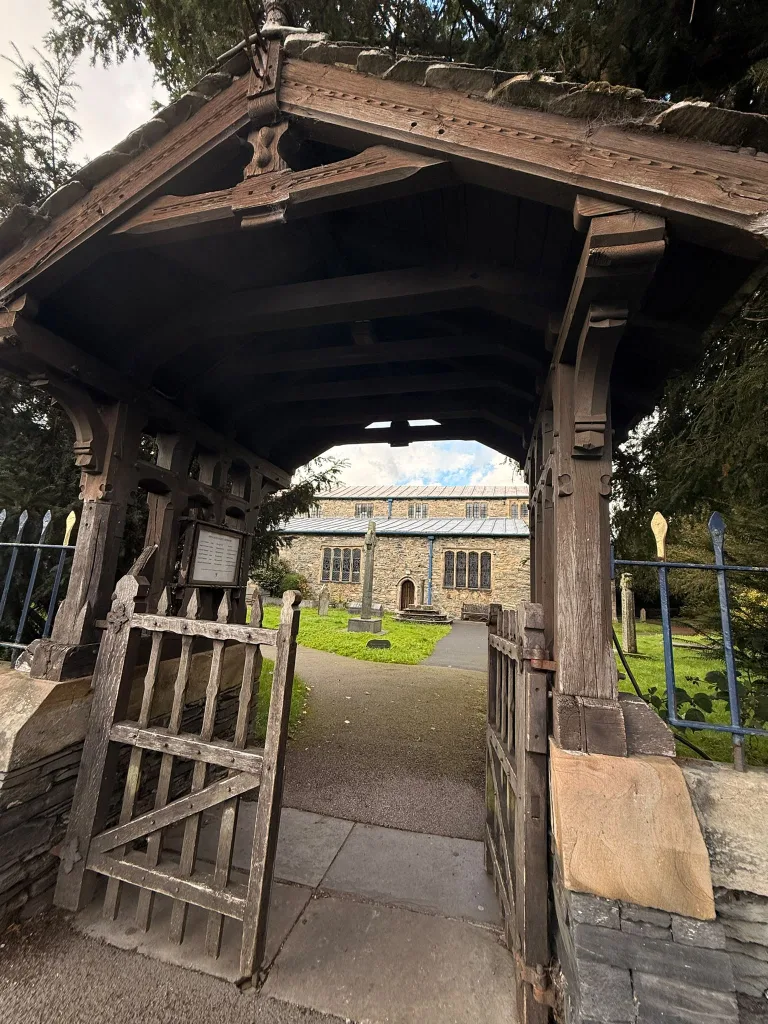The wooden lychgate at St Martin's Church, Bowness, framing the churchyard
